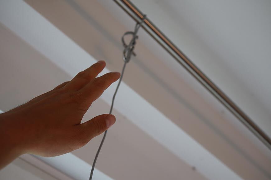 Das Sicherungsseil des Ecovacs WINBOT W1 PRO wird an der Gardinenstange befestigt